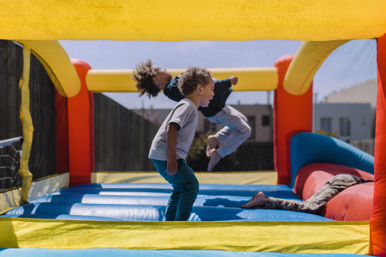 two boys jumping together in bouncy house {San Francisco Family Photographer}