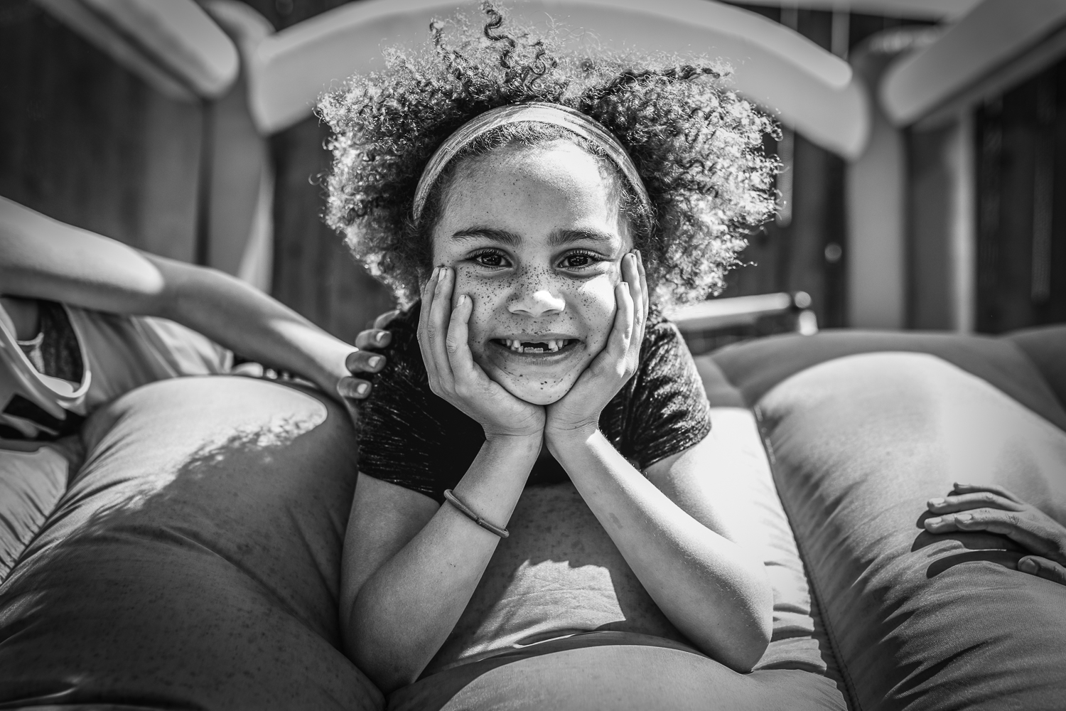 Girl looking at the camera and smiling while laying in bouncy house {San Francisco Family Photographer}