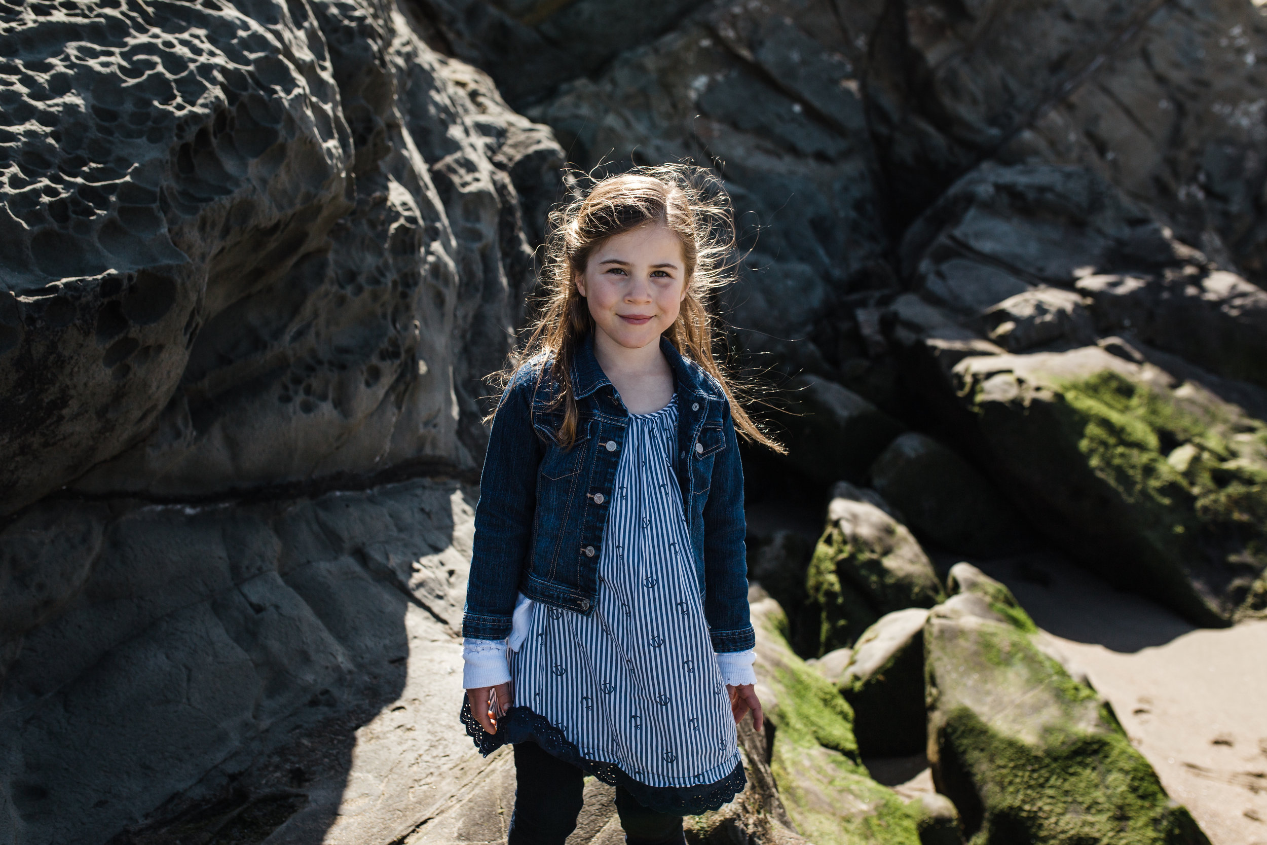 Portrait of a 5 year old girl standing on the rocks at Baker Beach {San Francisco Family Photography}