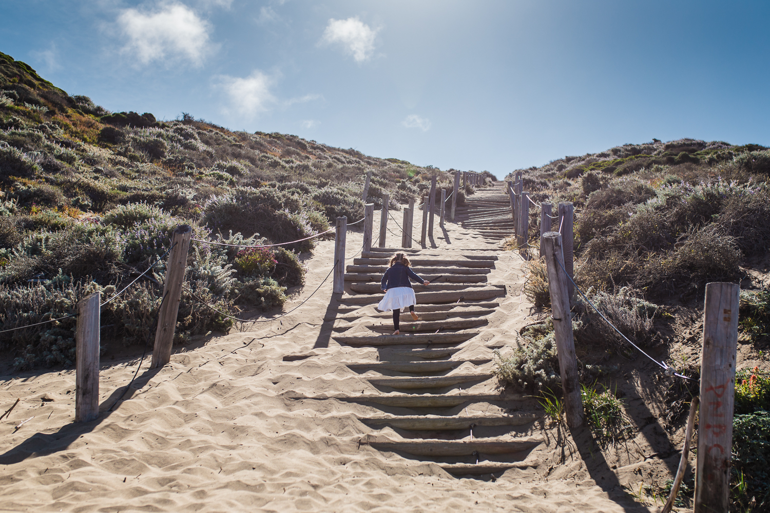 five year old girl climbing up sand stairs at Baker beach {Bay Area On-Location Family Photographer}