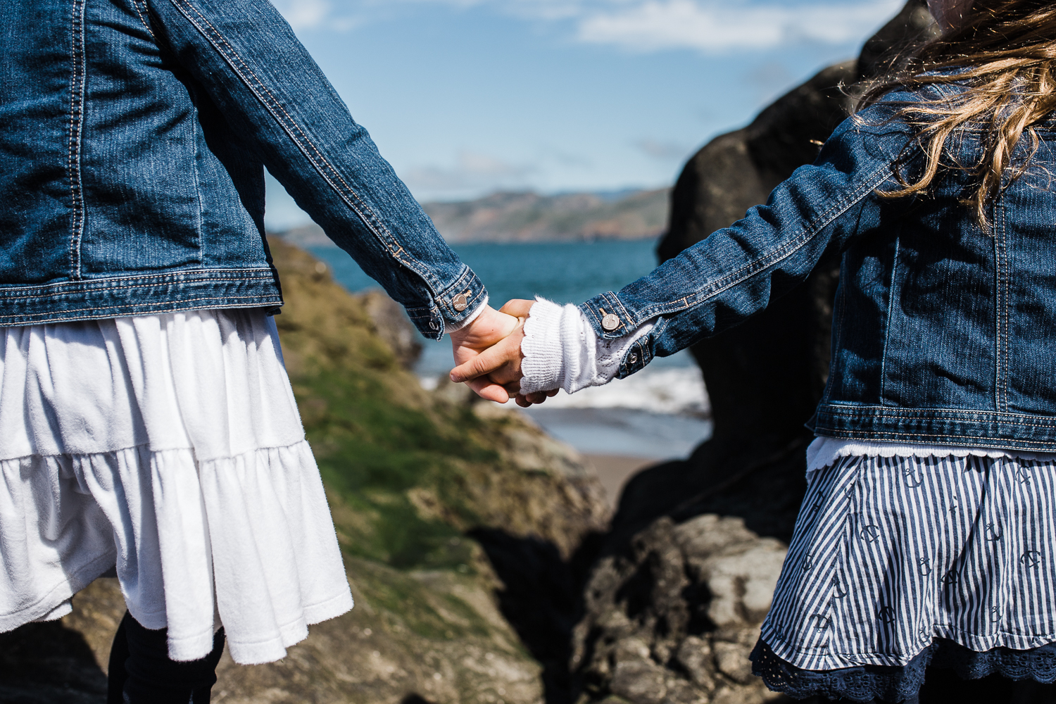 five year old twin girls holding hands and looking out at the ocean at Baker Beach {San Francisco Lifestyle Family Photographer}