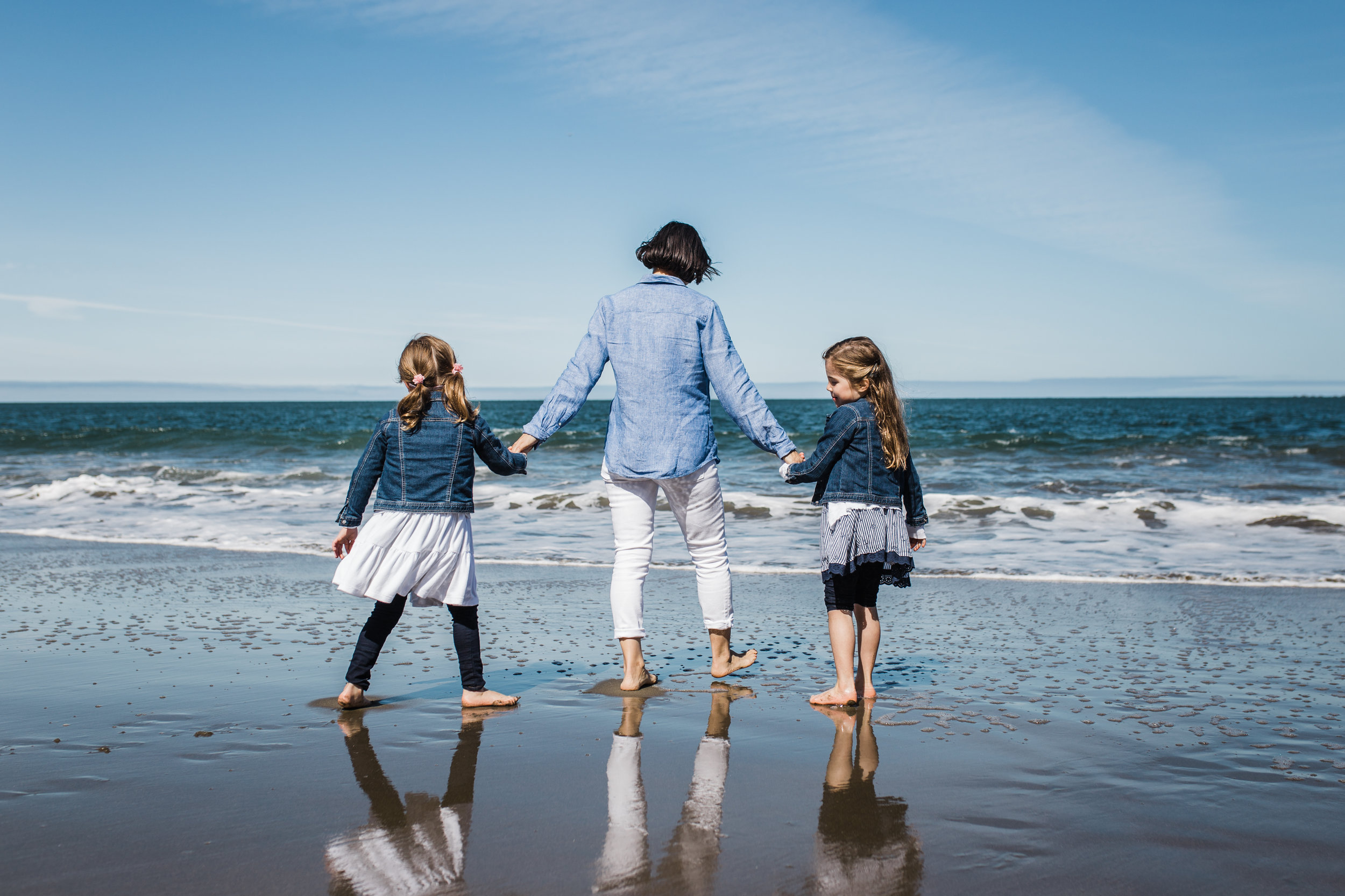 mom and her twin five year old girls holding hands and walking on Baker Beach towards the water {San Francisco Family Photographer}