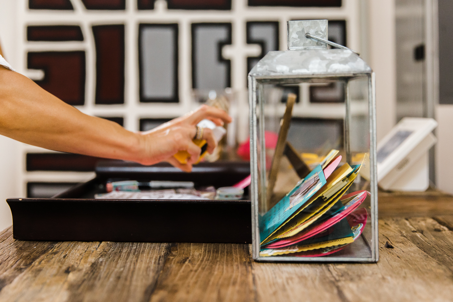 A person’s hand as they place a paper into a jar that contains advice for new parents 