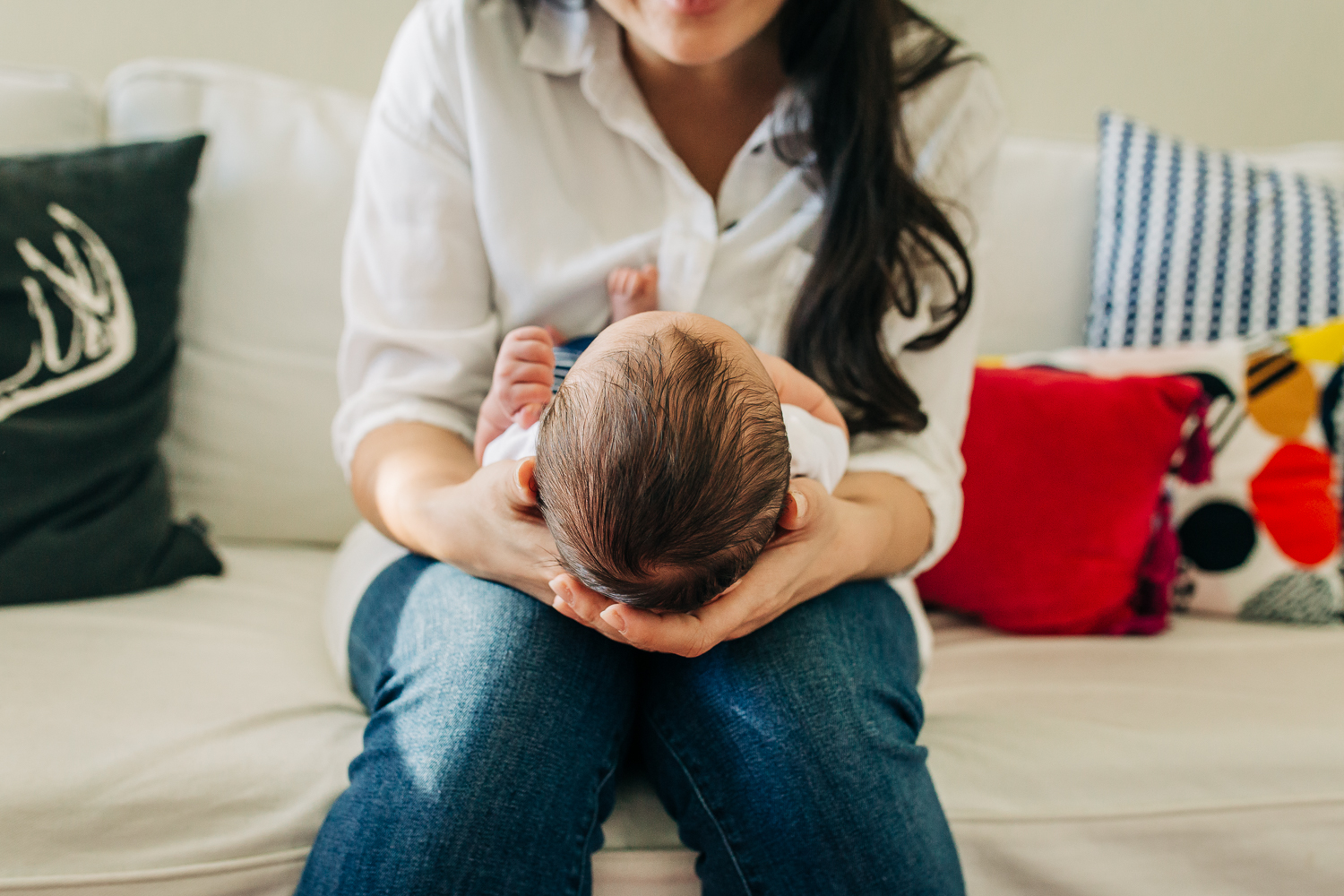 Close up of baby boy's head as  mom holds him and looks down at his face 