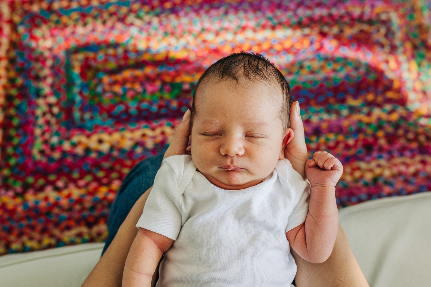 birds eye view of baby boy above a colorful carpet 