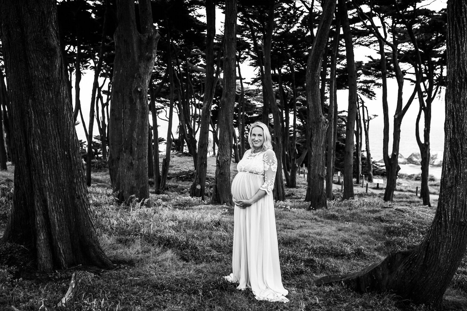 portrait of a pregnant woman standing in the woods 