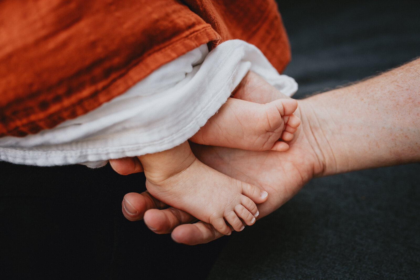 dad holding baby boy's feet 