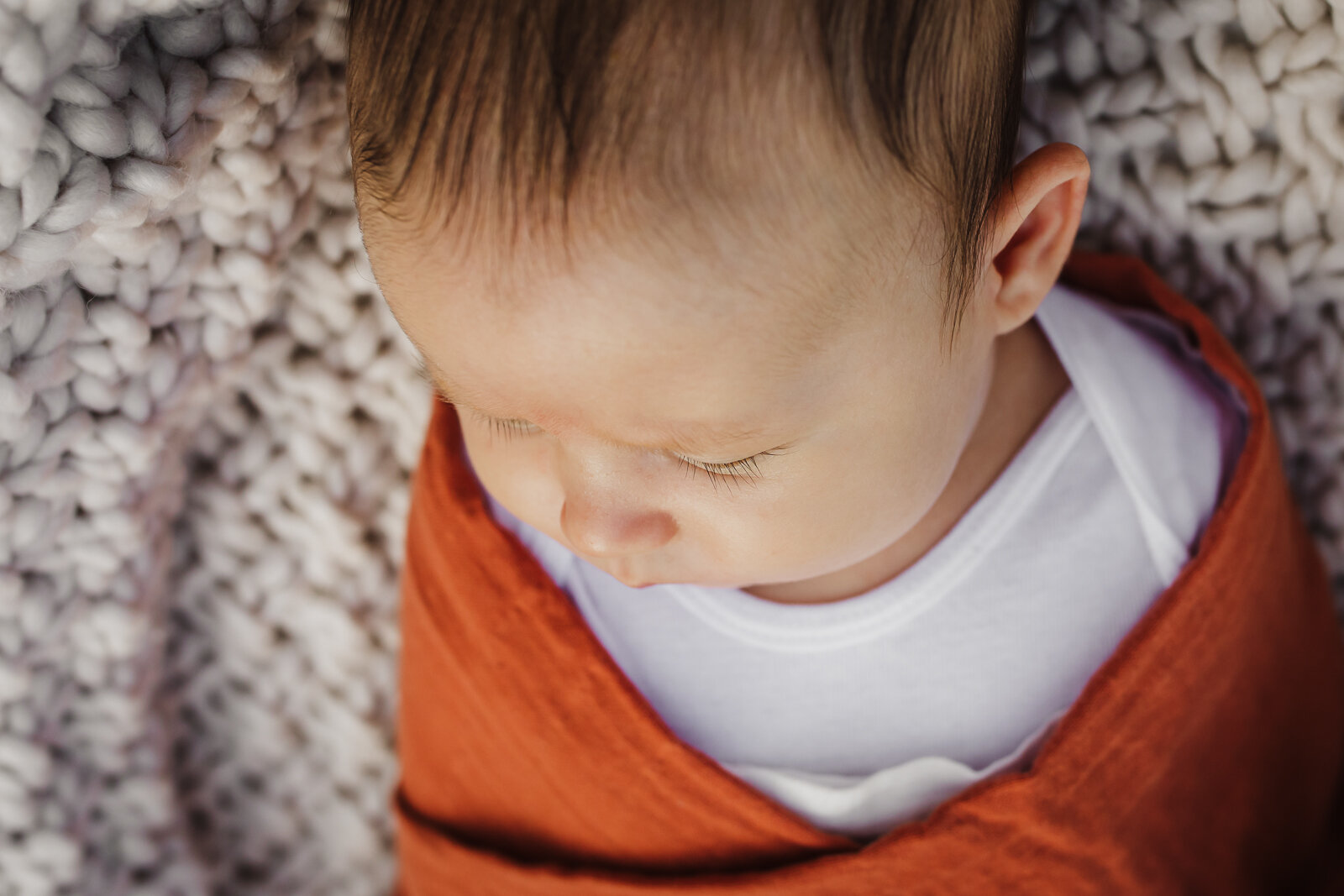 angled portrait of new baby boy swaddled 