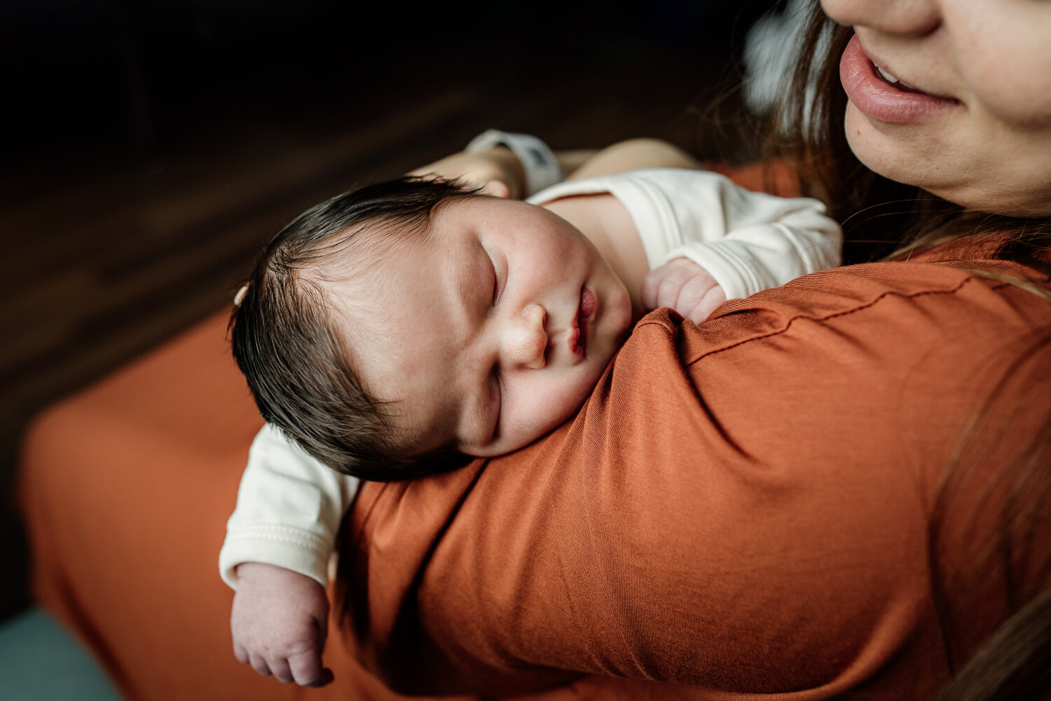 newborn sleeping on mom's shoulder in the hospital