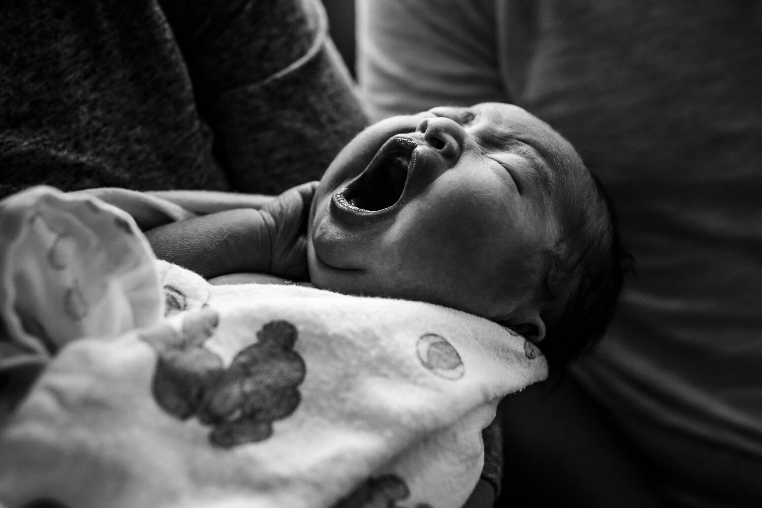 swaddled newborn yawning