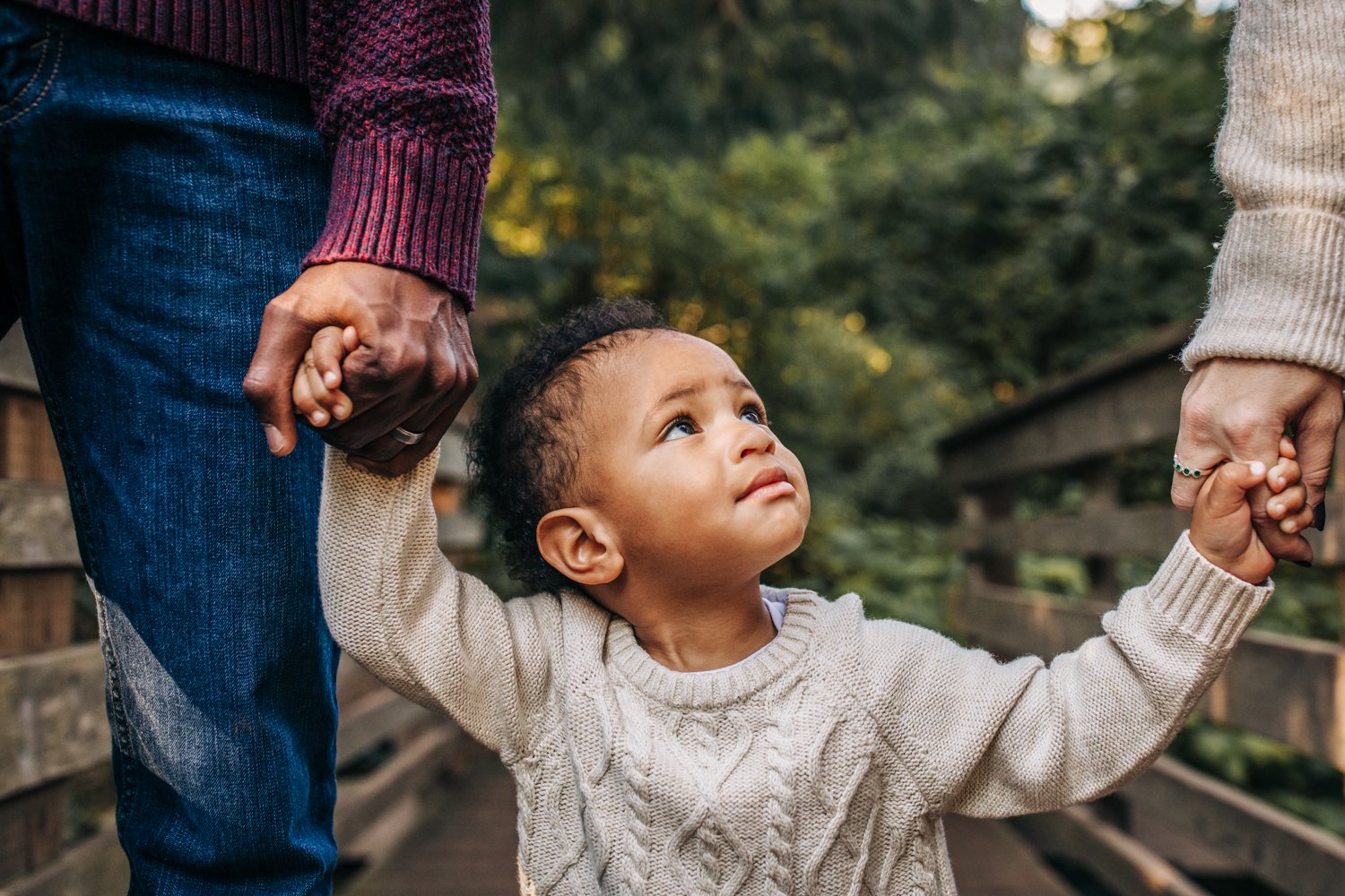 toddler walking with parents