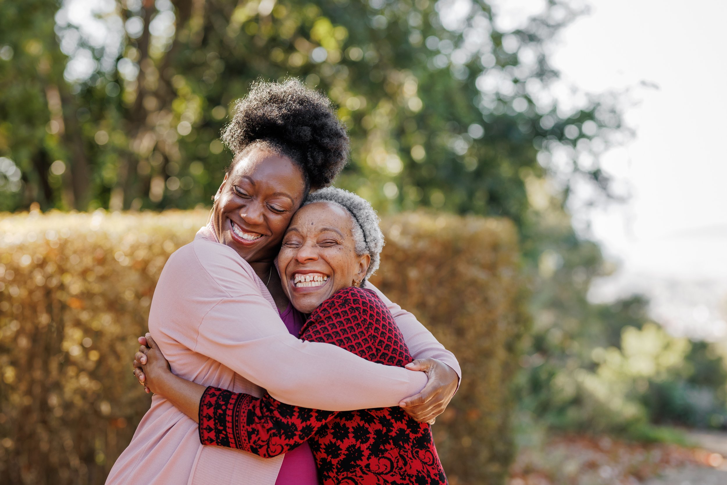 adult mother and daugther smiling and hugging each other during outdoor Berkeley maternity session.jpg