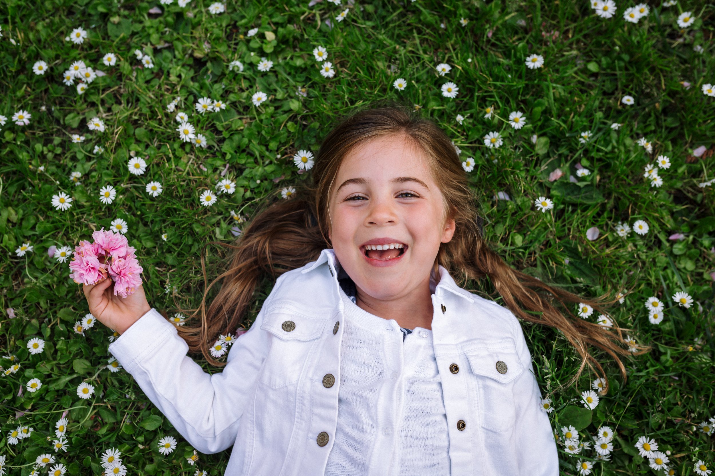 girl-laying-in-flowers-smiling.jpg.