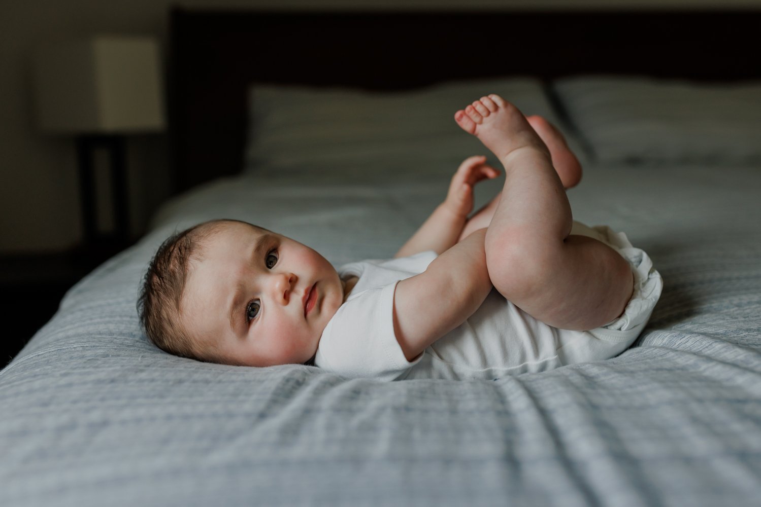 Baby-laying-on-back-on-bed