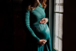 close-up-mother-holding-baby-bump-fort-point-maternity-session