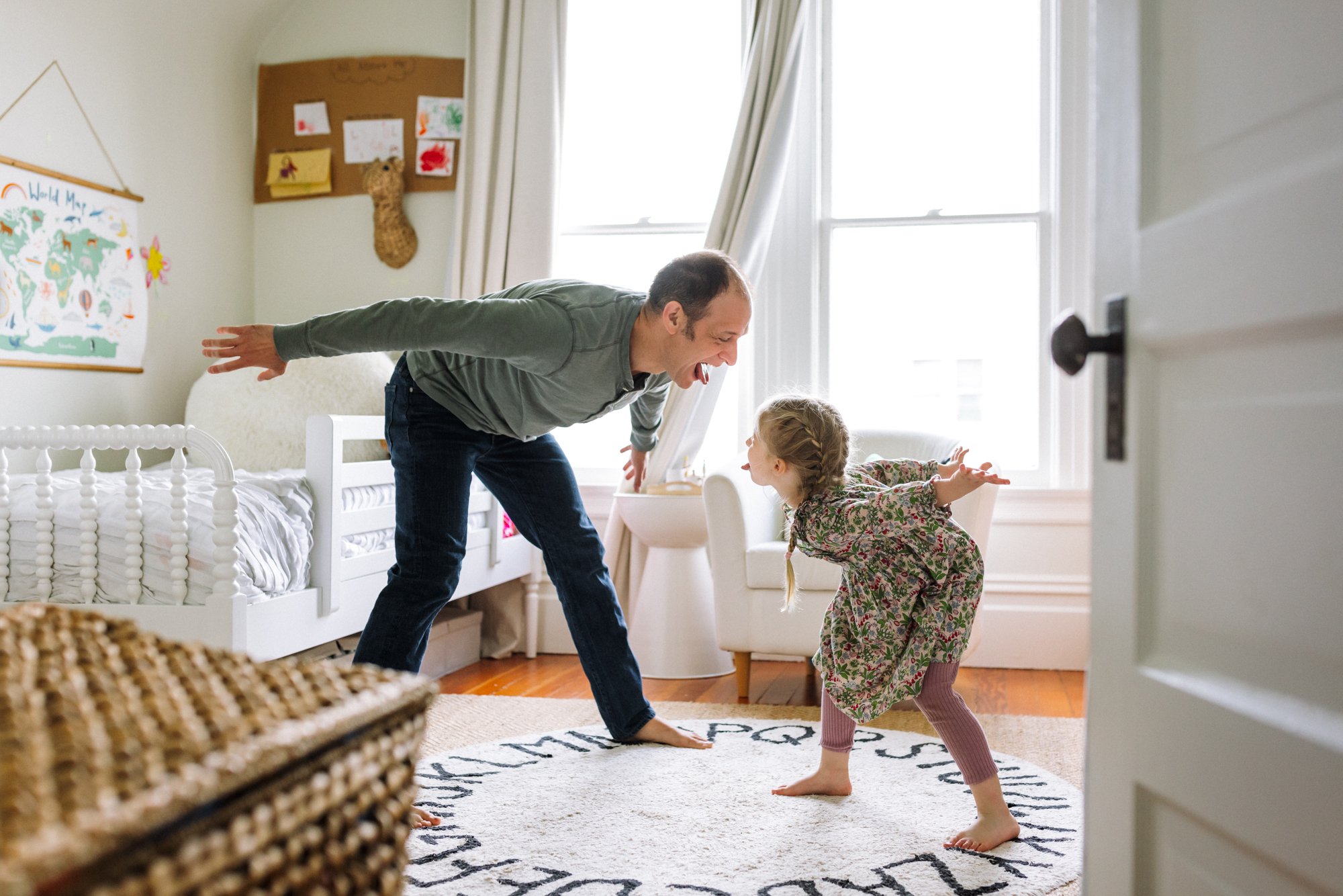 dad and 5-year-old daughter looking at each other dancing with their tongues out