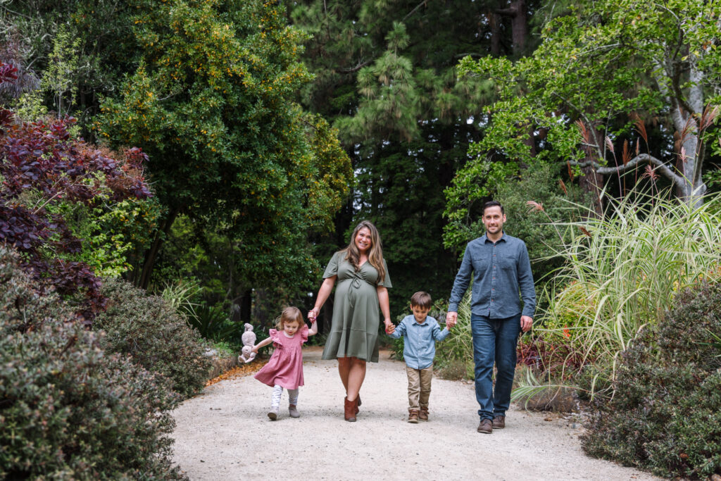 Family walking hand-in-hand in a wooded park setting