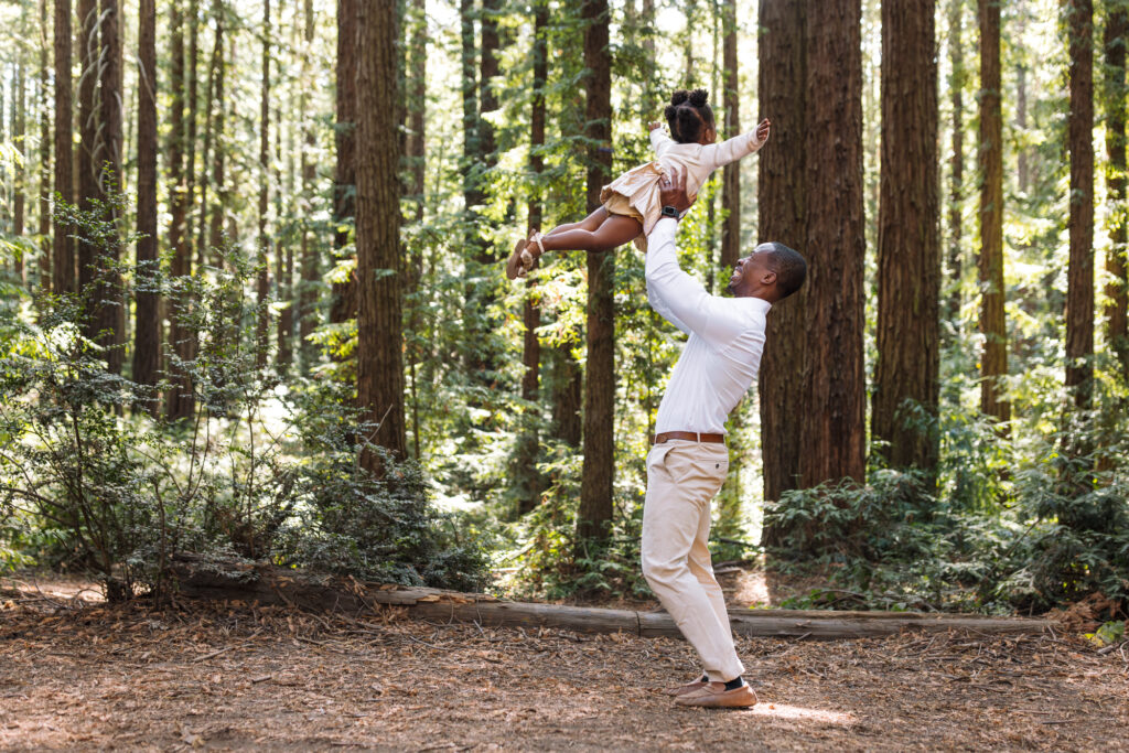Father lifting toddler in the air during a joyful moment outdoors