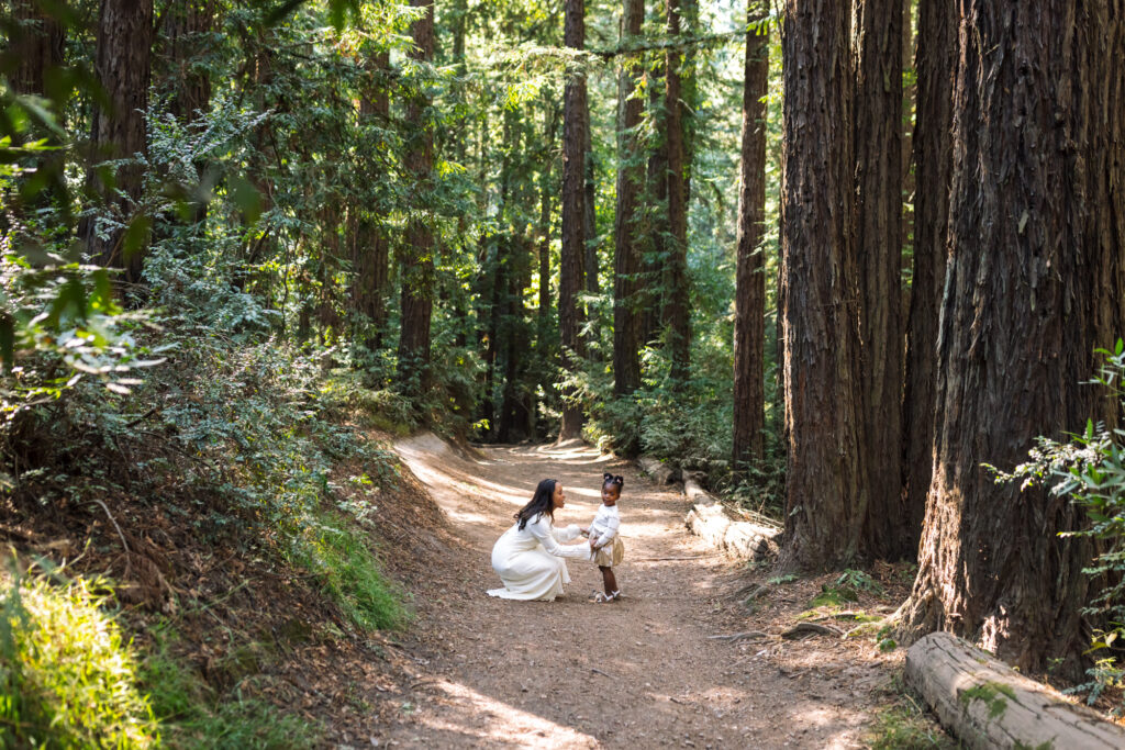 mother kneeling down with toddler girl in the Oakland redwoods