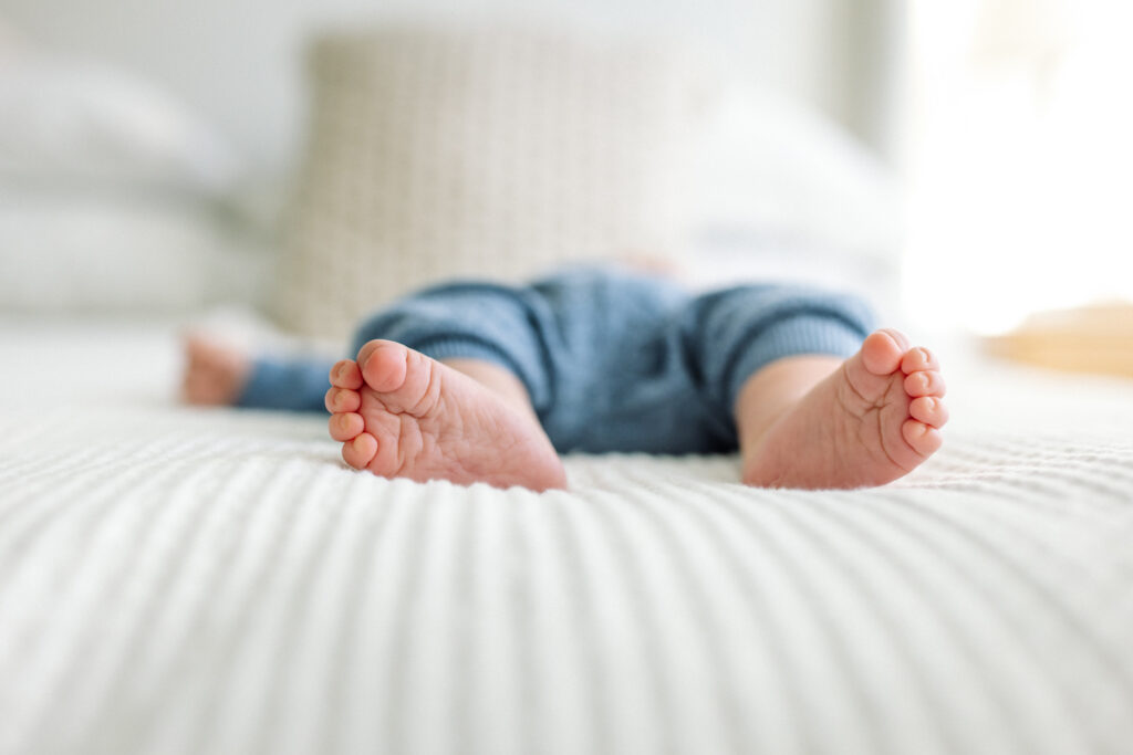 newborn baby feet on white bedding in-home newborn photography East Bay