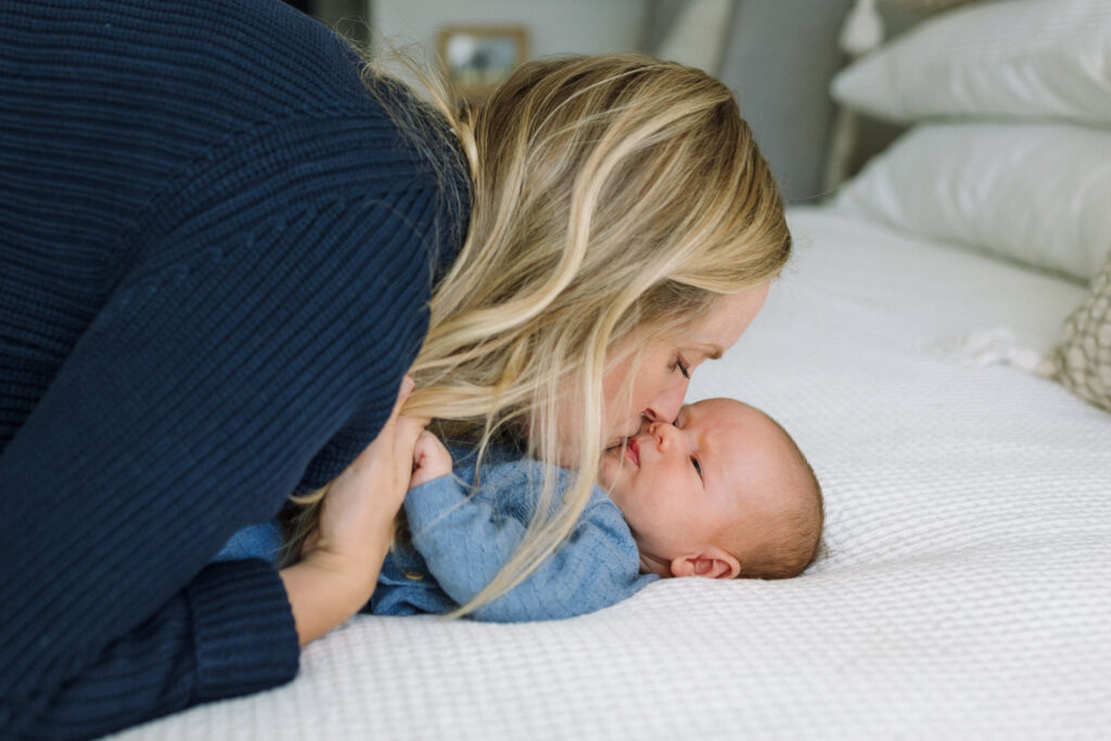 mom kissing newborn during in-home newborn photography East Bay