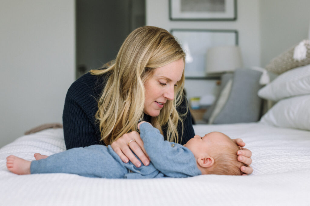 mom looking down at newborn during in-home newborn session East Bay