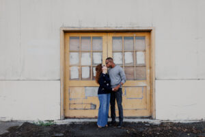 Couple standing together near a yellow door at the Alameda Naval Base