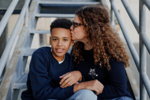Mom and son sitting close together on metal stairs during an Alameda family photography session