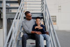 Dad and son sitting together on metal stairs during an East Bay family photography session