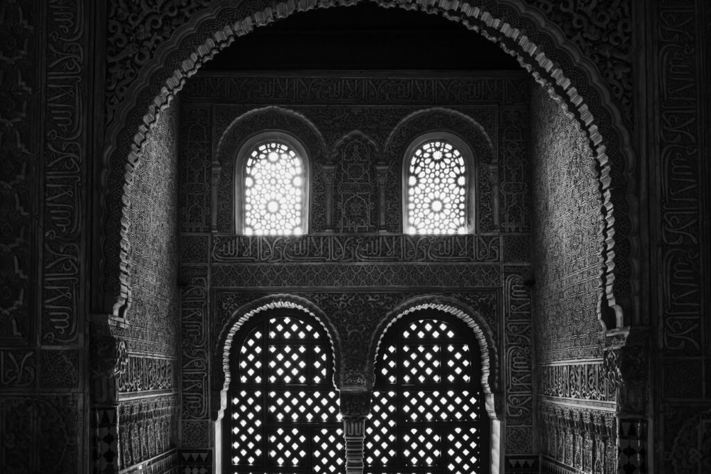 Moorish arches and latticed windows inside the Alhambra, Granada, Spain